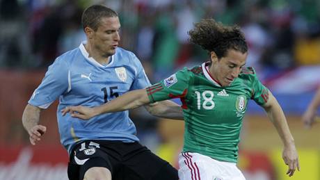 Andres Guardado z Mexika si kryje mí ped doráejícím Digem Pérezem z Uruguaye. 