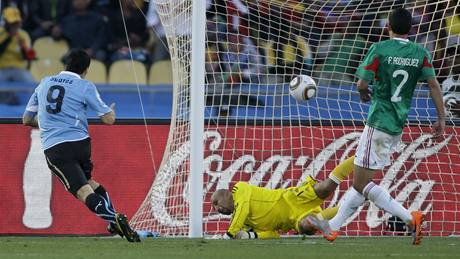 Uruguayec Luis Suárez (vpravo) práv� p�ekonal mexického branká�e Oscara Péreze.