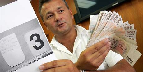 Kriminalista Pavel Kí ukazuje peníze, které pocházejí z loupených pepadení bank a pot v brnnském Králov Poli (8. ervenec 2010)