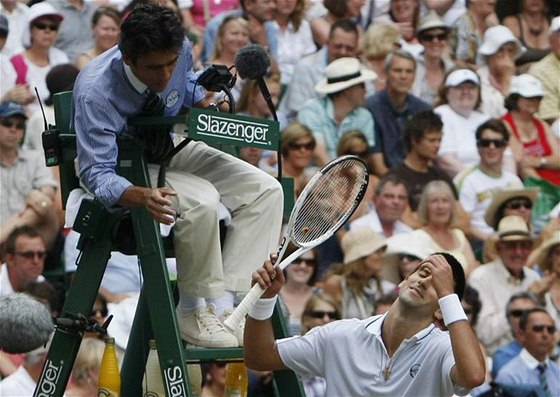 Novak Djokovi diskutuje s hlavním rozhodím o situaci v závru druhého setu wimbledonského semifinále proti Berdychovi