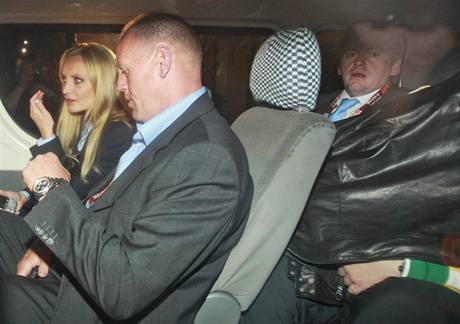 Paris Hilton (vpravo schovan pod bundou) pi odjezdu od jihoafrickho soudu. (2. ervence 2010)