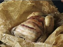 Po rozbalení pečicího papíru se objeví pečené kuřátko plné šťávy a se slaninkou připečenou na prsou