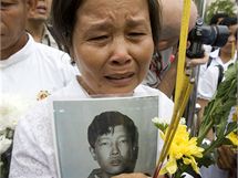 Kambodanka s portrtem svho bratra, vznnho za vldy Rudch Khmr ve vznici S-21, se astn budhistick ceremonie ve vznici S-21, dnes muzeu genocidy (25. ervence 2010)