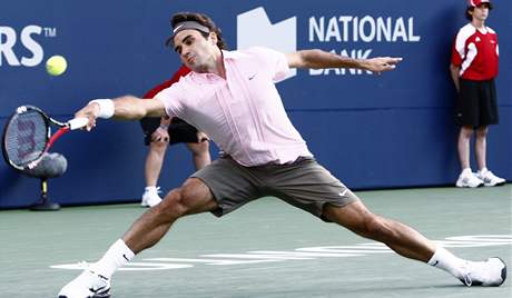 STÍHÁM. výcarský tenista Roger Federer se natahuje po míku a jet ho stíhá vybrat.