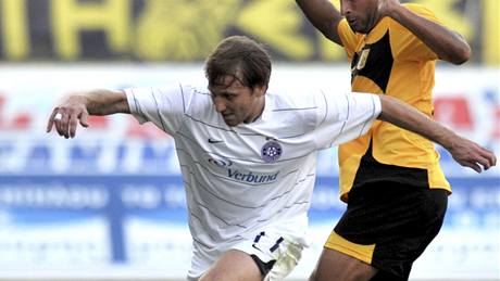 eský útoník Tomá Jun z Austrie Víde si kryje mí ped Mehdi Naftim, hráem Arisu Solu.