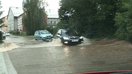 Po silnici stéká voda pi bleskové povodni v Libouchni