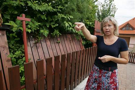 Monika Sovov ze lapanic ukazuje vyvrcen plot, kter si jej soused Grochovi postavili na erno