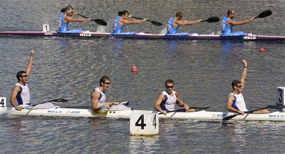 Francouská posádka (v bílém) Colin, Jouve, Hubert a Hybois se raduje z vítzství  vkategorii K4 na 1000 m. Za nimi je eská posádka Horský,Souek, Havel a trba. 