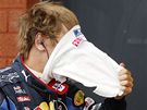 KDO TO JE? Ochrannou masku si práv sundává Nmec Sebastian Vettel ze stáje Red Bull.