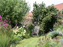 "Babiina" romantick zahrada pln kvtin, vpravo vedle houpacho keslka vstup do uitkov sti zahrady 