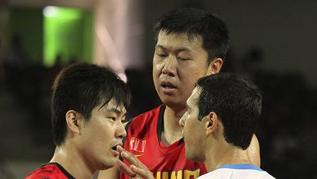 HOI, NEPERTE SE. Zhizhi Wang z íny ukliduje spoluhráe Shipenga Wanga v konfliktu s ekem Nikosem Zisisem pi utkání mistrovství svta basketbalist.