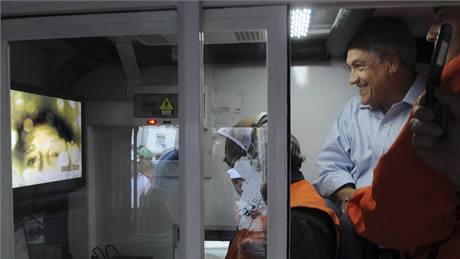 Chilský prezident Sebastian Pinera sleduje na obrazovce zábry na nich jsou uvznní horníci (22. srpna 2010)