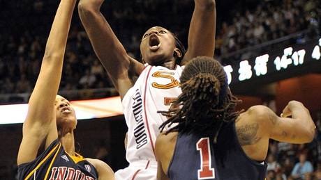 Tina Charlesová (uprosted) z Connecticutu Sun stílí v utkání WNBA na ko Indiany Fever pes Shavonte Zellousovou (vpravo) a Tammy Sutton-Brownovou