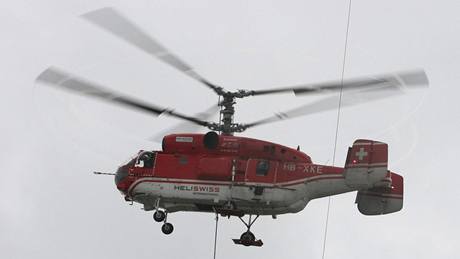 Dvourotorová helikoptéra Kamov Ka-32 odnáí díl staré antény z vysílae Pradd.