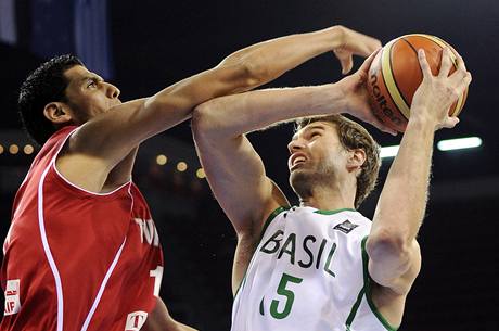 Tiago Splitter (vpravo) z Brazlie zakonuje pes Salaha Medriho z Tuniska