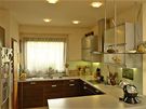 Kuchyn, vybavená moderní linkou z MDF desek s dezénem tropického deva a hliníkovými prvky, je od obývacího pokoje oddlena píkou
