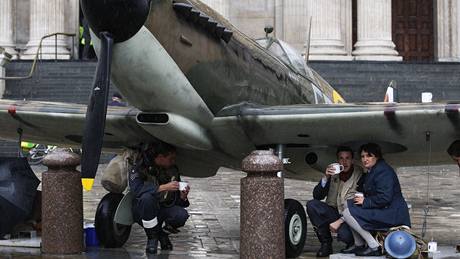 Příslušníci RAF v dobových kostýmech se schovávají před deštěm pod letounem Spitfire před katedrálou sv Pavla. Londýn si připomíná 70. výročí zahájení Blitzu (7. září 2010) 