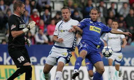 Liberecký gólman David Biík (vlevo) sleduje, jak dopadne souboj jeho spoluhráe  Radka Dejmka s olomouckým Romanem Hubníkem (vpravo).