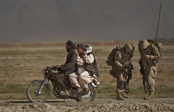 Afghánci na motorce míjí jihozápadn od Kandaháru dva kanadské vojáky