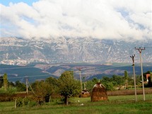Albánie. Hrozivá hradba hor – po levé straně se uprostřed masivu rýsuje zástavba města Krujë