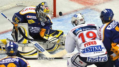 K zakonení se ped zlínskými hrái Romanem Vlachem (vlevo) a Daliborem ezníkem (vpravo) tlaí pardubický Pivko (v bílém). V pohotovosti je branká Jakub Sedláek.