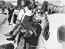 Mbuyiswa Makhubu nakládá do automobilu postřeleného dvanáctiletého Hectora Pietersona. Jeden z dalších pěti, méně slavných snímků zachycujících jeho smrt (16. června 1976)