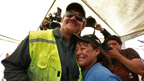 P�íbuzná jednoho ze zavalených horník� v Chile objímá experta na vrtání Jeffa Harta