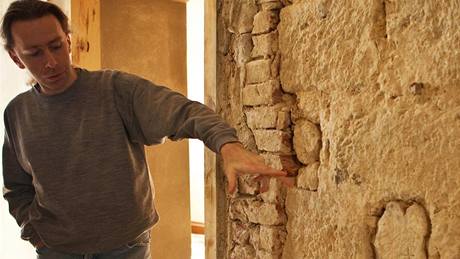 Archeologické nálezy objevené bhem rekonstrukce ásti zámku v Dín. Stavební historik David Otáhal ukazuje zazdívku dveního otvoru tvoenou ebry gotické klenby.