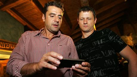 Karlovarský primátor a lídr kandidátky ODS Werner Hauptmann (vlevo) sleduje s Ivanem Vrzalem prbné výsledky na obrazovce iPhone. Volební táb karlovarské ODS se v sobotu seel v restauraci U imla. 