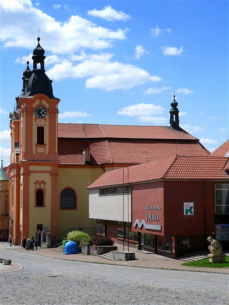 Nepomuk, kostel sv. Jana Nepomuckého zčásti zakrytý budovou nákupního střediska