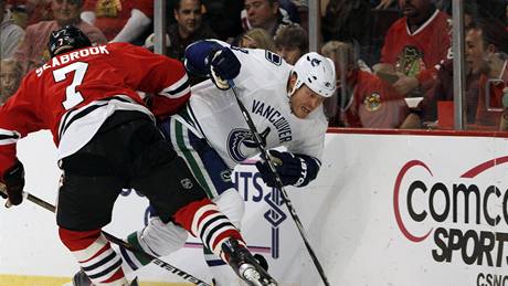 Raffi Torres z Vancoueru (vpravo) a Brent Seabrook z Chicaga v souboji u mantinelu.