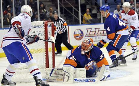 Tomá Plekanec (vlevo) z Montrealu v anaci ped gólmanem Dwaynem Rolosonem z New York Islanders.