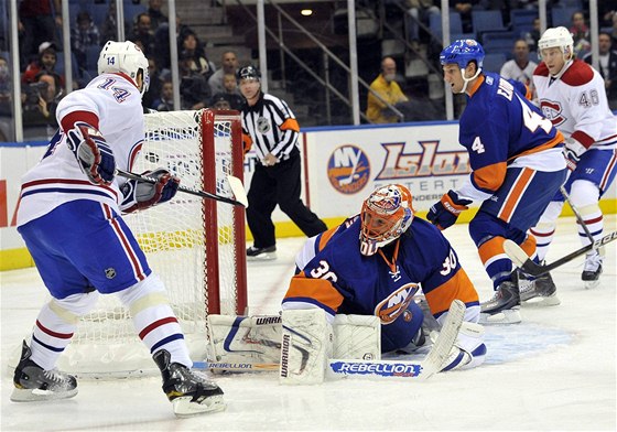 Tomá Plekanec (vlevo) z Montrealu v anaci ped gólmanem Dwaynem Rolosonem z New York Islanders.