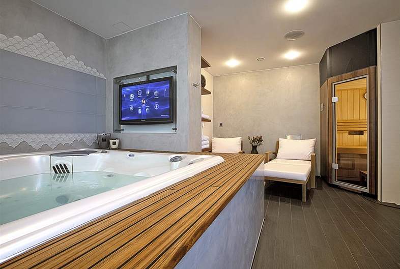 Jedna z koupelen slouí jako domácí lázn: masání vana Persea (USSPA) pro 5 osob, sauna (Villeroy & Boch) a vudypítomné televizní obrazovky