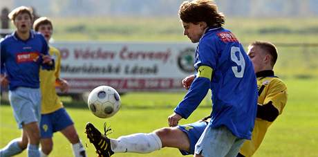 Kapitán Drmoulu Vlastimil Kotous (v modrém) v derby s Mariánskými Láznmi.