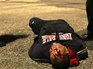 VÝTRNÍK. Jeden z fanouk Baníku Ostrava leí na zemi s krvavým rámem. Policisté ho zadreli, protoe ped stadionem dlal nepoádek. Slzný plyn pak peruil i zápas s Plzní. 