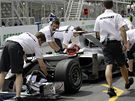 Vz Mercedes s Michaelem Schumacherem v kokpitu zatlaují mechanici do garáe.