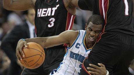 JAKO BULDO�EK. Bojoval Chris Paul z New Orleans (v bílém). Brání ho hrá�i Miami Chris Bosh (vpravo) a Dwyane Wade (vlevo). 