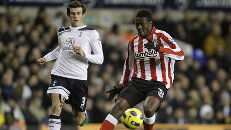 Gareth Bale z Tottenhamu bedliv sleduje jak si zpracovává mí útoník Sunderlandu Asamoah Gyan.