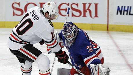 Branká New Yorku Rangers Henrik Lundqvist elí nájezdu Patricka Sharpa z Chicaga. 