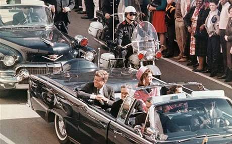 JFK s Jacqueline projídjí ulicemi Dallasu. Do smrtících výstel zbývají okamiky.