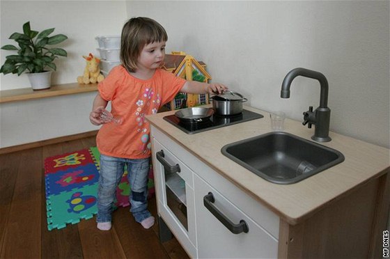 Dvouletá Rozálka v dtské kuchyni, ve které si hraje na hospodyku