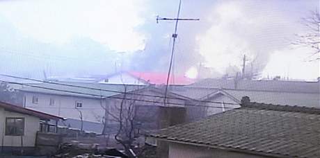 Hořící domy na ostrově Jeonpjeong po severokorejském ostřelování (23. listopadu 2010)