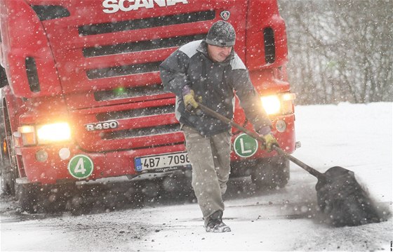 idi kamionu zstal stát mezi Bílicemi a Leskovcem nad Moravicí na Bruntálsku. Sype pod kola kváru, aby se mohl rozjet. (29. listopadu 2010)