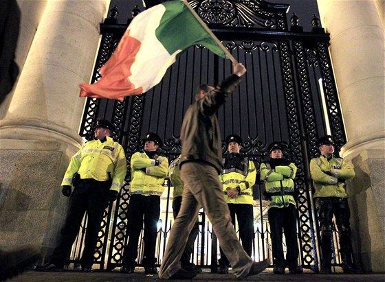 Demonstrant s irskou vlajkou ped budovou ministerstva financí v Dublinu.