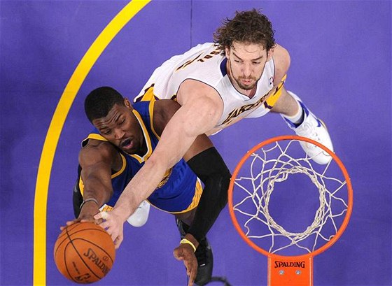 Jeff Adrien (vlevo) z Golden State Warriors zakonuje pes Paua Gasola z LA Lakers