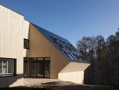 Stecha Slunenho domu je pokryt fotovoltaickmi panely a solrnmi kolektory, mezi nimi jsou nainstalovna sten okna Velux