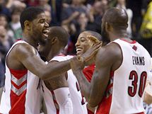 Amir Johnson (vlevo) se se svmi spoluhri z Toronta Raptors raduje z spn koncovky proti Bostonu Celtics