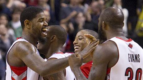 Amir Johnson (vlevo) se se svými spoluhrái z Toronta Raptors raduje z úspné koncovky proti Bostonu Celtics