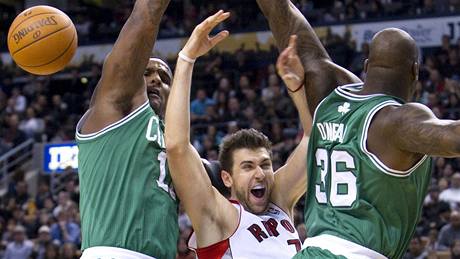 Andrea Bargnani (uprosted) z Toronta Raptors narazil na obranu Bostonu Celtics. Brání ho Glen Davis (vlevo) a Shaquille O'Neal 